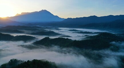 Scenery of Mount Kinabalu forest with low clouds on the morning from aerial scene.