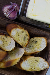 Garlic bread served on a wooden tray.