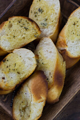 Garlic bread served on a wooden tray.