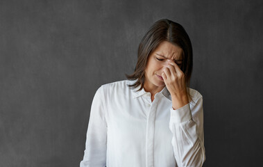 Businesswoman looking stressed while standing in front of a chalkboard