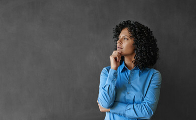 Entrepreneur standing by a chalkboard and thinking about her business