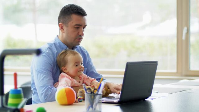 remote job, multi-tasking and family concept - middle-aged father with baby working on laptop at home office
