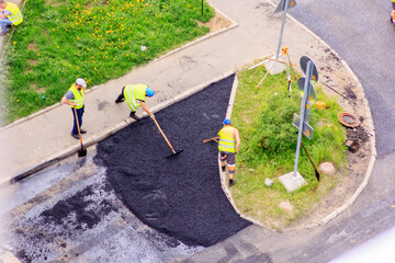 road workers lay asphalt, road repair, sidewalk, three road workers