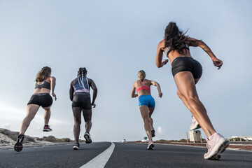 Unrecognizable diverse athletes running together