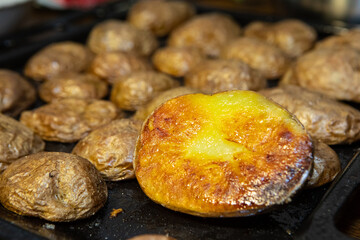 Macro photo of baked browned potatoes. Delicious and healthy food, close up view
