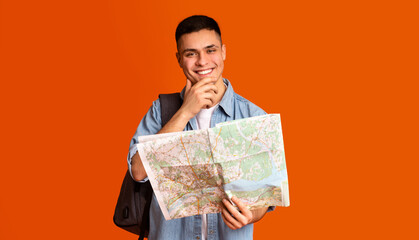 Positive guy making sightseeings, using city map