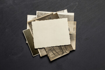 Vintage blank paper sheet over pile of old retro family photo cards