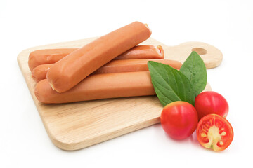 Hot Dog sausages on cutting board with tomatoes and basil isolated on white background
