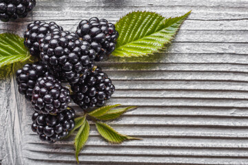 juicy blackberries on gray wooden rustic background