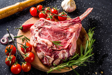 Cooking meat background. Raw tomahawk steak, with spices and herbs for cooking on a gray table...