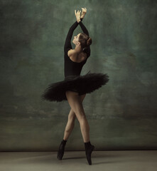 Art motion. Graceful classic ballerina dancing, posing isolated on dark studio background. Elegance black tutu. Grace, movement, action and motion concept. Looks weightless, flexible. Fashionable.