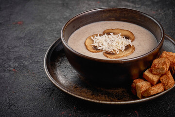 Creamy Mushroom Soup with crackers on the black background.
