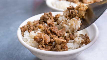 Braised meat rice, stewed beef over cooked rice in Tainan, Taiwan. Taiwanese famous traditional street food delicacy. Travel design concept, closeup.