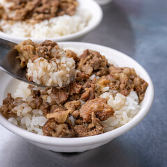 Braised meat rice, stewed beef over cooked rice in Tainan, Taiwan. Taiwanese famous traditional street food delicacy. Travel design concept, closeup.