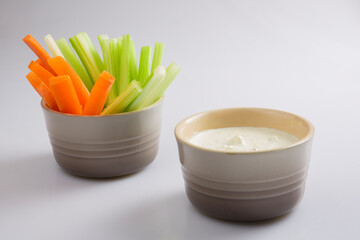 close up isolated shot of a bowl of separated crunchy orange carrot slices and juicy green celery...