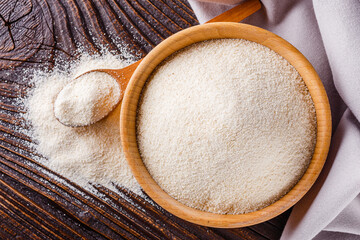 natural organic semolina on dark wooden rustic background
