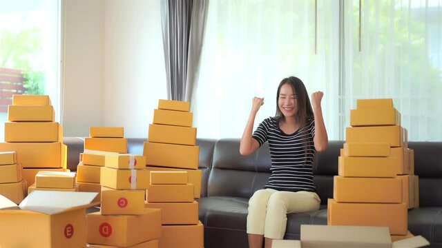 Startup small business entrepreneur SME freelance Asian woman with boxes, Young happy success Asian woman with hand lift up, online marketing packaging box and delivery, SME concept