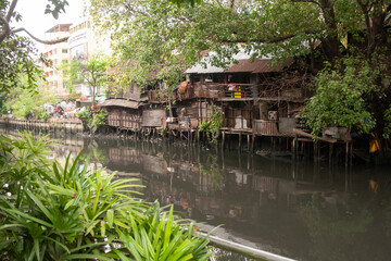 Fototapeta na wymiar Poor and dirty hovels above the river in Bangkok suburban, Thailand
