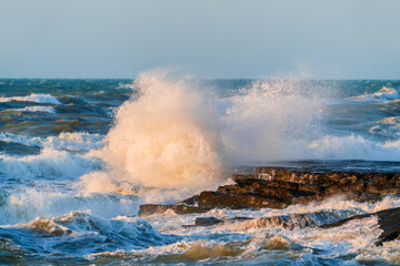 Fototapeta na wymiar Big waves crash against coastal cliffs. Sea storm