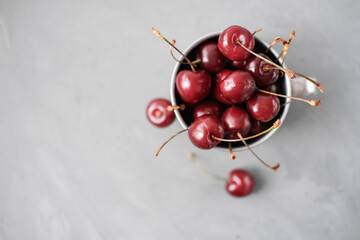 Obraz na płótnie Canvas fresh cherries with water drops in metallic mug. top view. poster or summer calendar page. summer antioxidant berries for heart health.