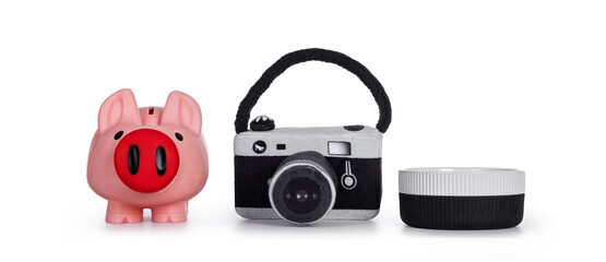 Piggy bank, toy photo camera and empty ceramic (food) on a row. Isolated on white background.