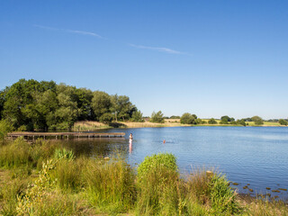 Warm weather visitors enjoying time in the water at Pickmere lake, Pickmere, Knutsford, Cheshire, UK