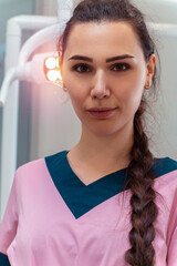 beautiful dentis in pink uniform smiles on camera