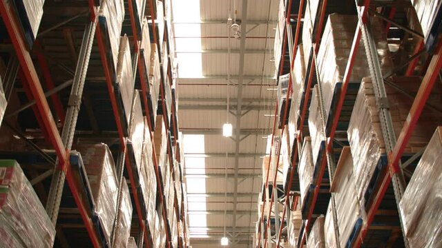 Upward Shot / Moving through Hallway of a Warehouse, Factory with tall Shelves 