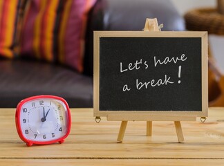 Image of motivational greeting Let's have a break on chalk board. Besides a decorative green plant in vase. Selective focus on notice board. Others in gradient blur.