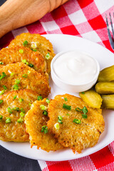 Delicious crispy potato pancakes on dark stone background