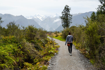 Woman walking with a view of the Fox Glacier