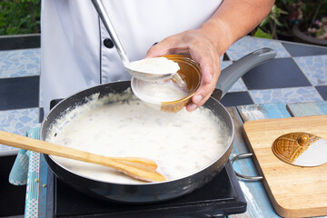 Chef spoon mushroom cream soup into a cup