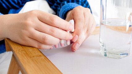 Obraz na płótnie Canvas Closeup image of female hands opening pills