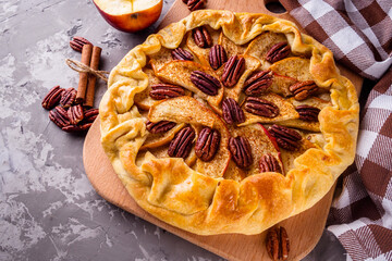 crispy apple galette with pecans on a rustic wooden background