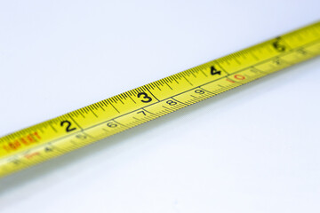 Tape measure closeup with out of focus elements on a white background