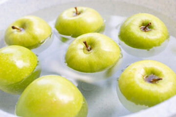 Soak green apple in water. Washing fruit concept