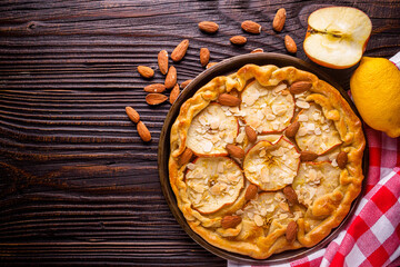 crispy apple galette with almonds on rustic wooden background