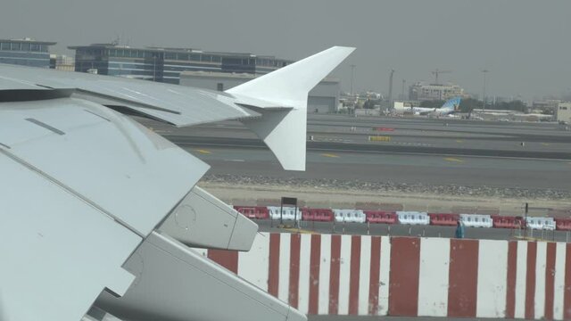 Slow motion shot of airplane pulling onto lane in airport. Hot desert morning