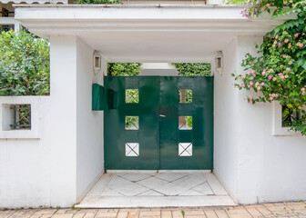 modern apartment building entrance portico with green painted door by the sidewalk