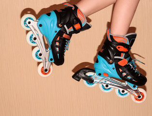 Roller skates on the child's feet on a beige background.