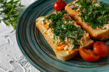 A couple of vegetable sandwiches on fresh white bread with cheese, carrots and crab meat, decorated with dill greens, next to cherry tomatoes and a fragrant garlic smell of snacks