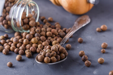 fresh spicy peppers allspice on a dark stone background