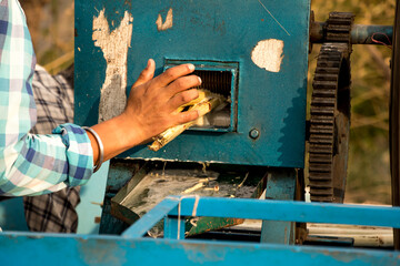 Image of machine crushing sugarcane to get its juice