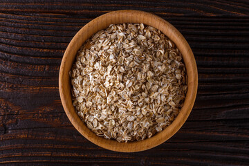 raw oatmeal on a wooden rustic background
