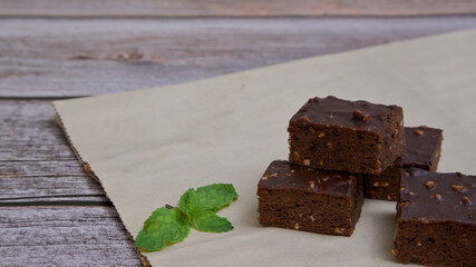 Chocolate brownies nuts squares on wooden table.