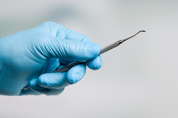 Dentist's hand in blue gloves with dental instruments
