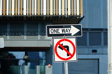 One way street sign n Manhattan, New York City, USA and Do not turn left traffic sign on white.    ...