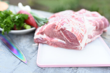 raw meat on a cutting board. raw beef steak. bowl of green grass