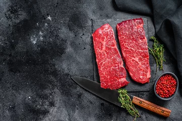 Poster Marble beef Denver steak with herbs. Organic meat. Black background. Top view. Copy space © Vladimir