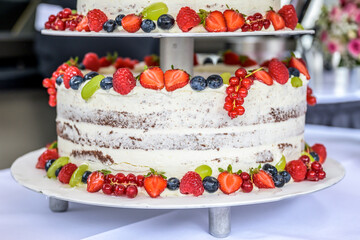 beautiful delicious Wedding cake in many tiers with fresh wild berries and fruits